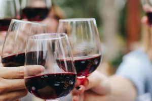 people tossing their clear wine glasses